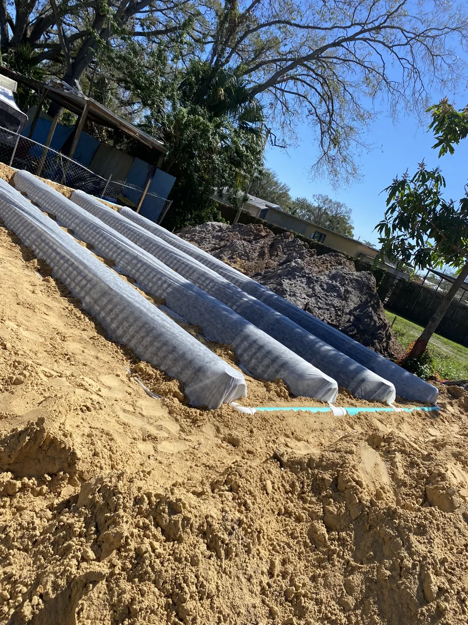 Drain field components in an excavated area before backfilling