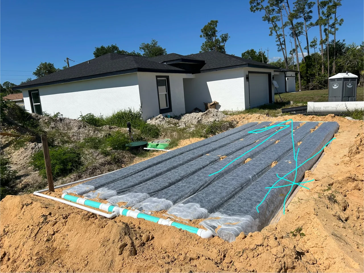 Annotated drain field photo showing components and connections before backfilling