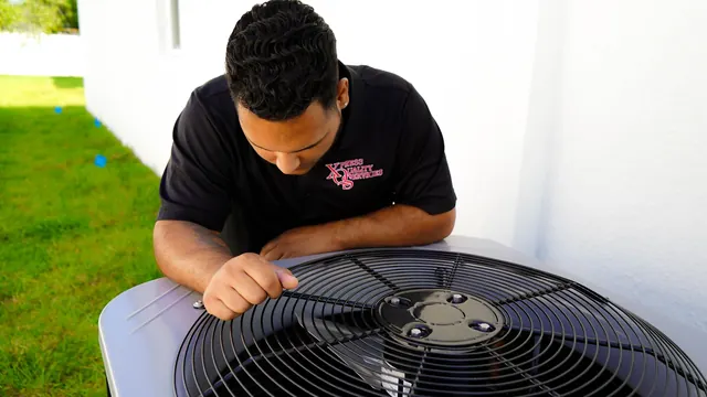 XQS technician inspecting the fan grille of an outdoor AC condenser, photo from XQS Google Business Profile