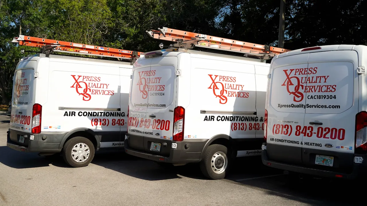 Three XQS service vans parked together.