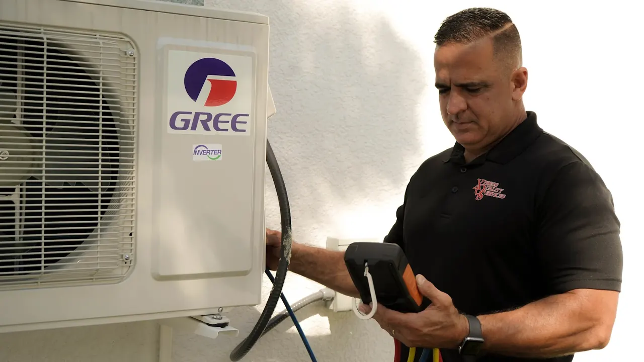 XQS technician testing a ductless mini split outdoor unit with a digital gauge