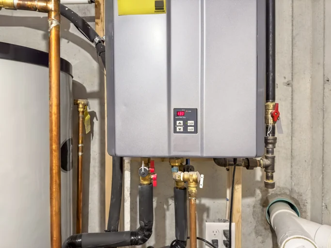 Wall-mounted tankless water heater and connected piping