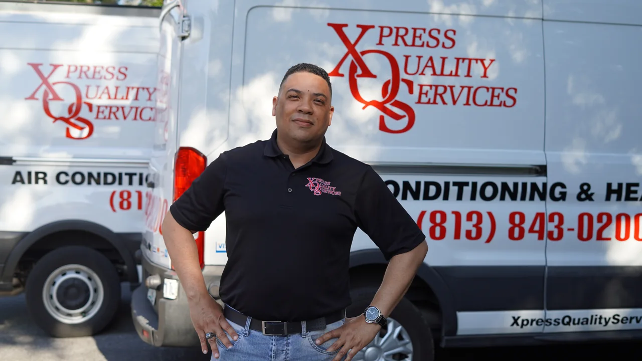 XQS team member beside a branded service van