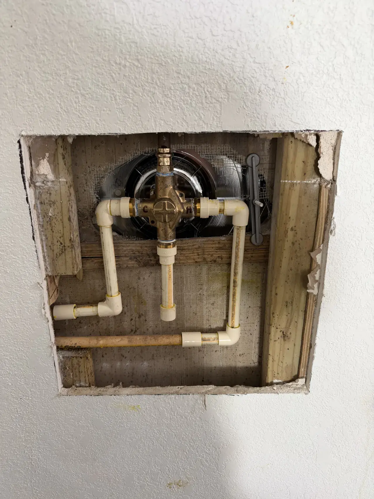 Plumbing access and pipe connections documented during leak repair in St. Petersburg.