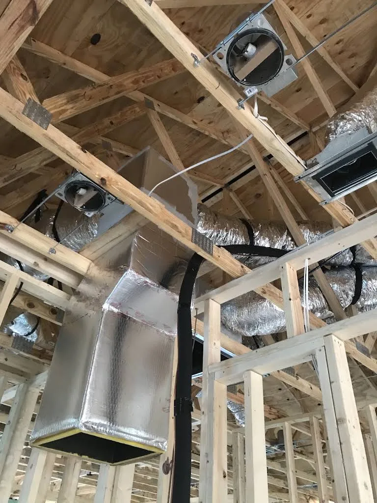 Ductos HVAC aislados y conexiones de techo entre estructuras de madera expuestas, foto publicada por XQS