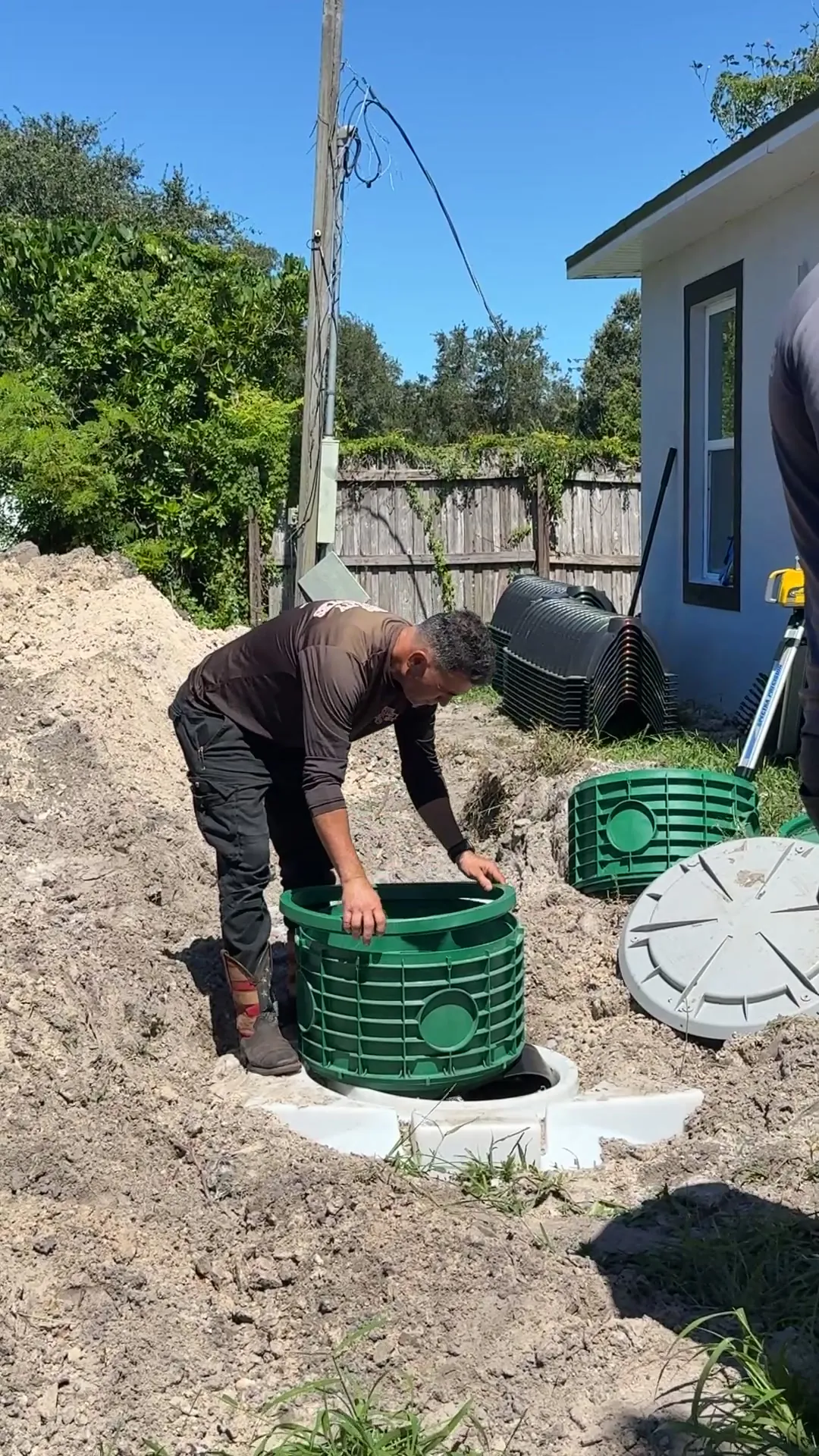 XQS technician setting a green riser on a new septic tank