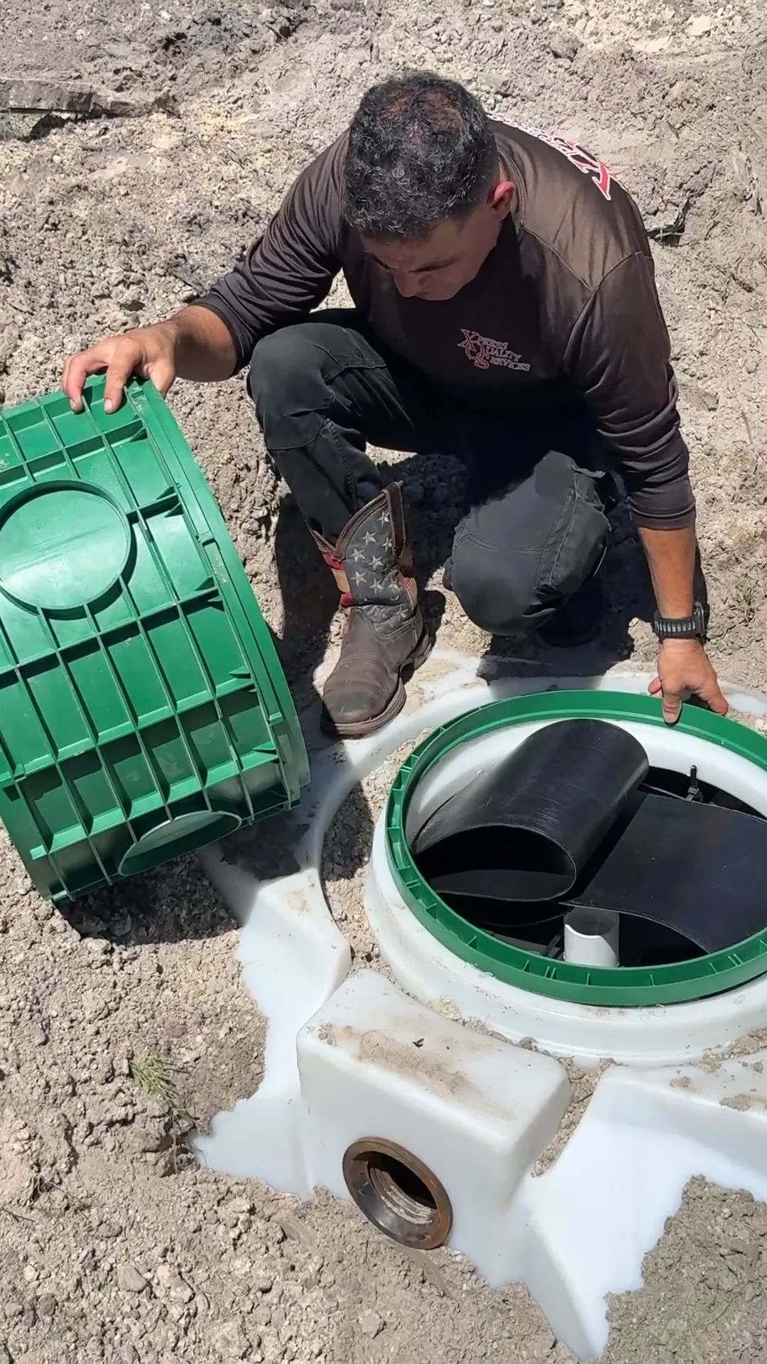 XQS technician fitting a riser section onto a septic tank access