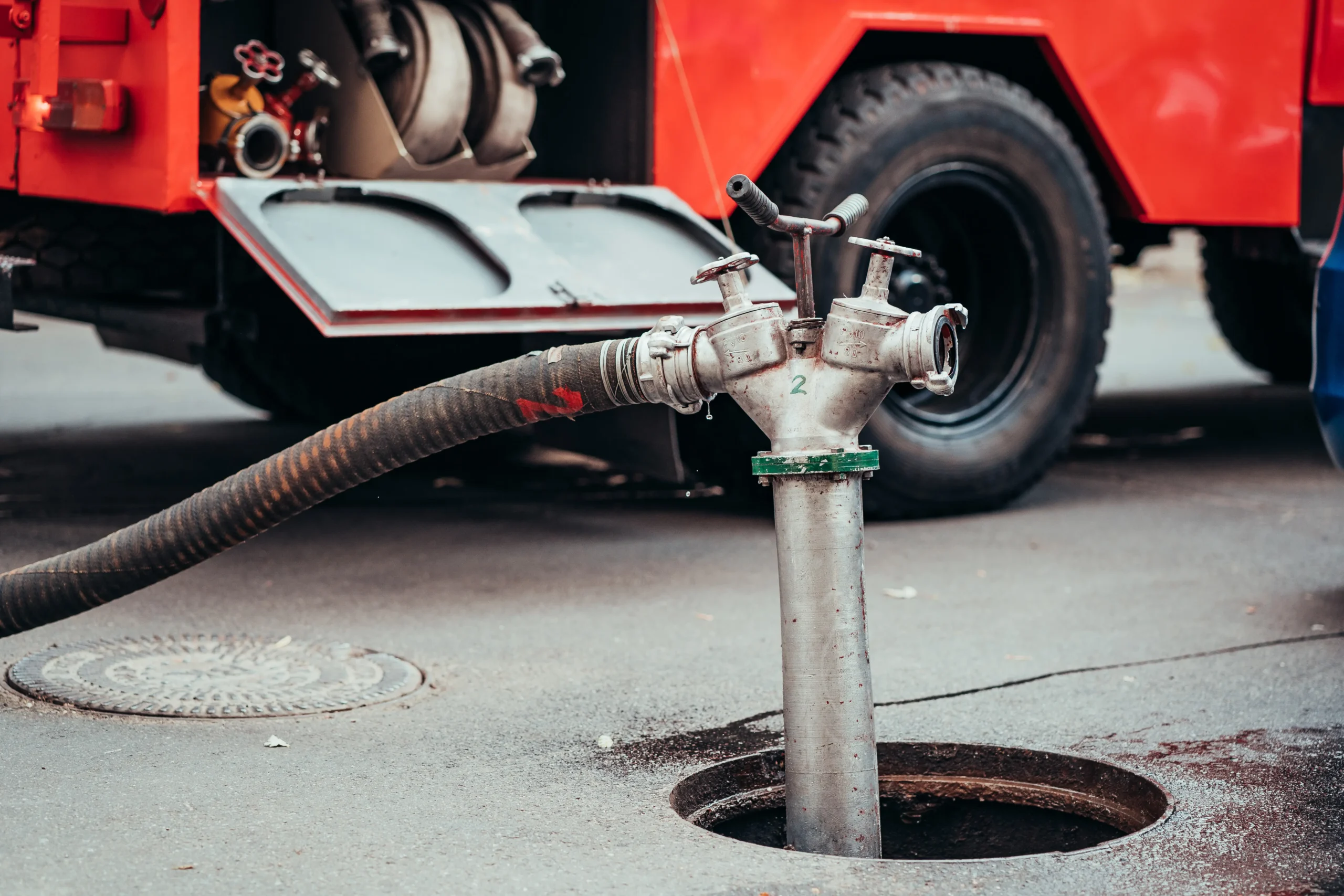 Service truck hose connected to an underground wastewater access point
